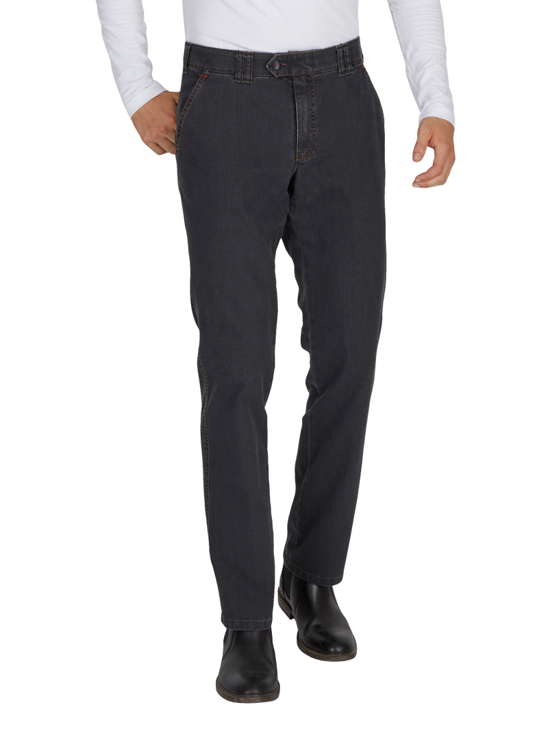 Herrenhat jeans in dunkler Waschung, mit geradem Schnitt, sichtbaren Nähten, Gürtelschlaufen und Taschen vorne sowie hinten, kombiniert mit schwarzen Schuhen.