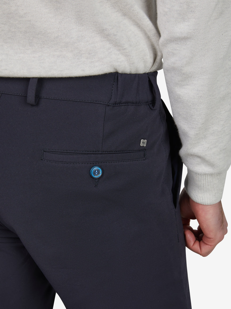 Nahaufnahme einer dunkelblauen, slim-fit Chino-Hose von Club of Comfort mit elastischem Smokbund, Hemdstopper, mittlerer Leibhöhe, einer luxuriösen Mikrofaser-Struktur, einer Blauen Knopfleiste, einer hinteren Gesäßtasche und einem Logo-Tag.