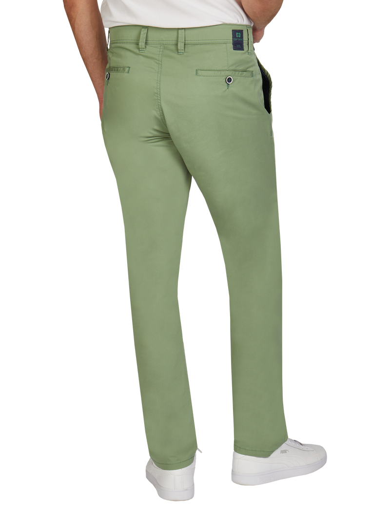 Blick auf die Rückseite einer Person, die grüne Hosen trägt. Die Hosen sind locker sitzend mit Gürtelschlaufen, zwei hinteren Taschen mit Knopfverschluss und einem verdeckten Etikett am Gürtel. Die Person trägt weiße Sneakers.