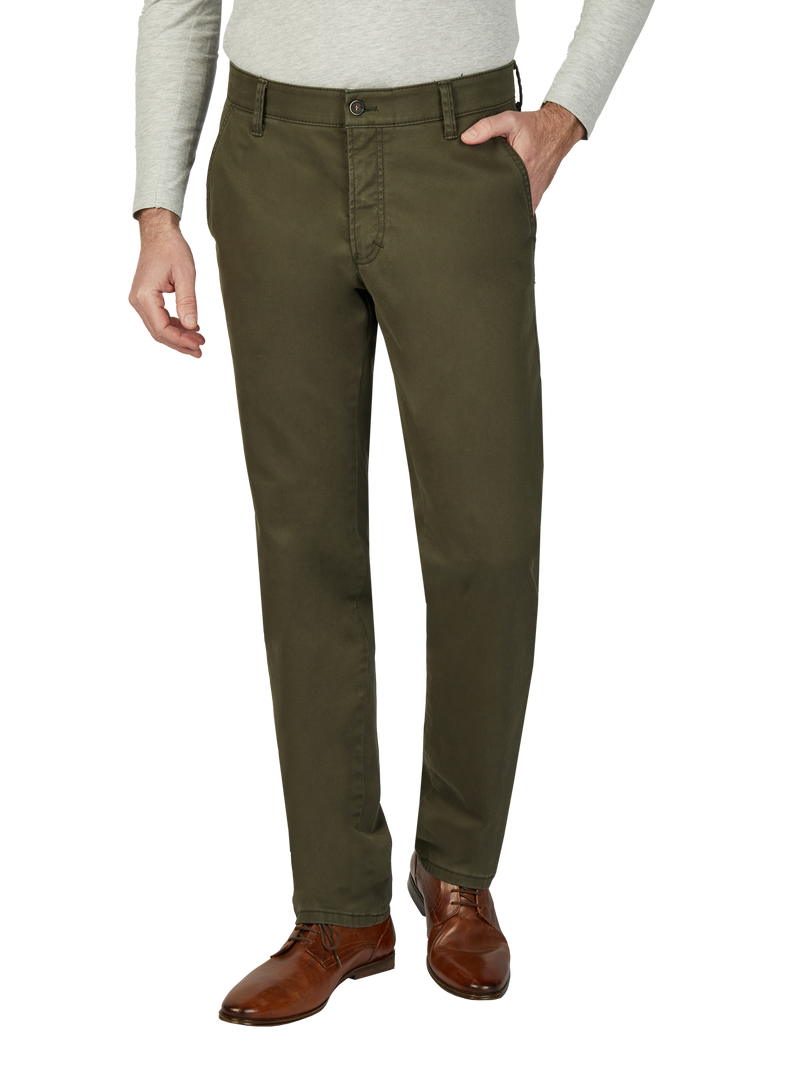 Herrenhose in Olivgrün, gerade Schnitt, mit schlichten Design, seitliche Eingrifftaschen und Knopfverschluss. Der Träger trägt die Hose zu einem hellgrauen Pullover und braunen Lederschuhen.