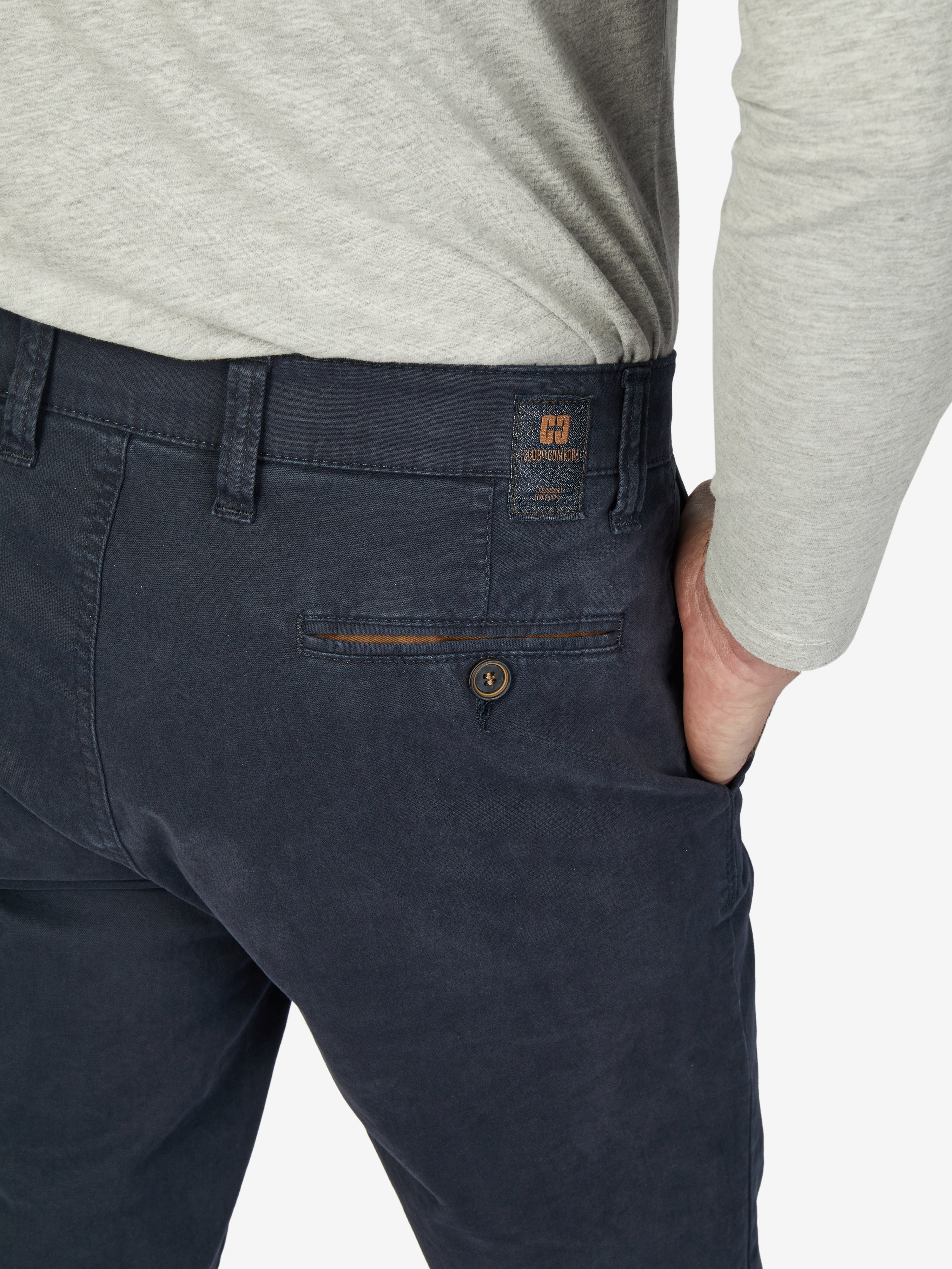 Nahaufnahme einer dunkelblauen GARVEY 7612 Flat Front-Hose aus elastischer Baumwolle mit elastischem Komfortbund, Hemdenstopper und Münztasche in der rechten Seitentasche, getragen von einer Person in einem hellgrauen Oberteil.