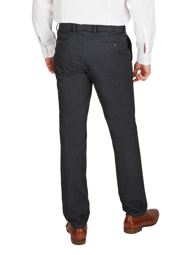 Herren in dunklen, formellen Anzughosen, die hinten fotografiert werden. Die Person trägt braune Lederschuhe und ein weißes Hemd mit langen Ärmeln.