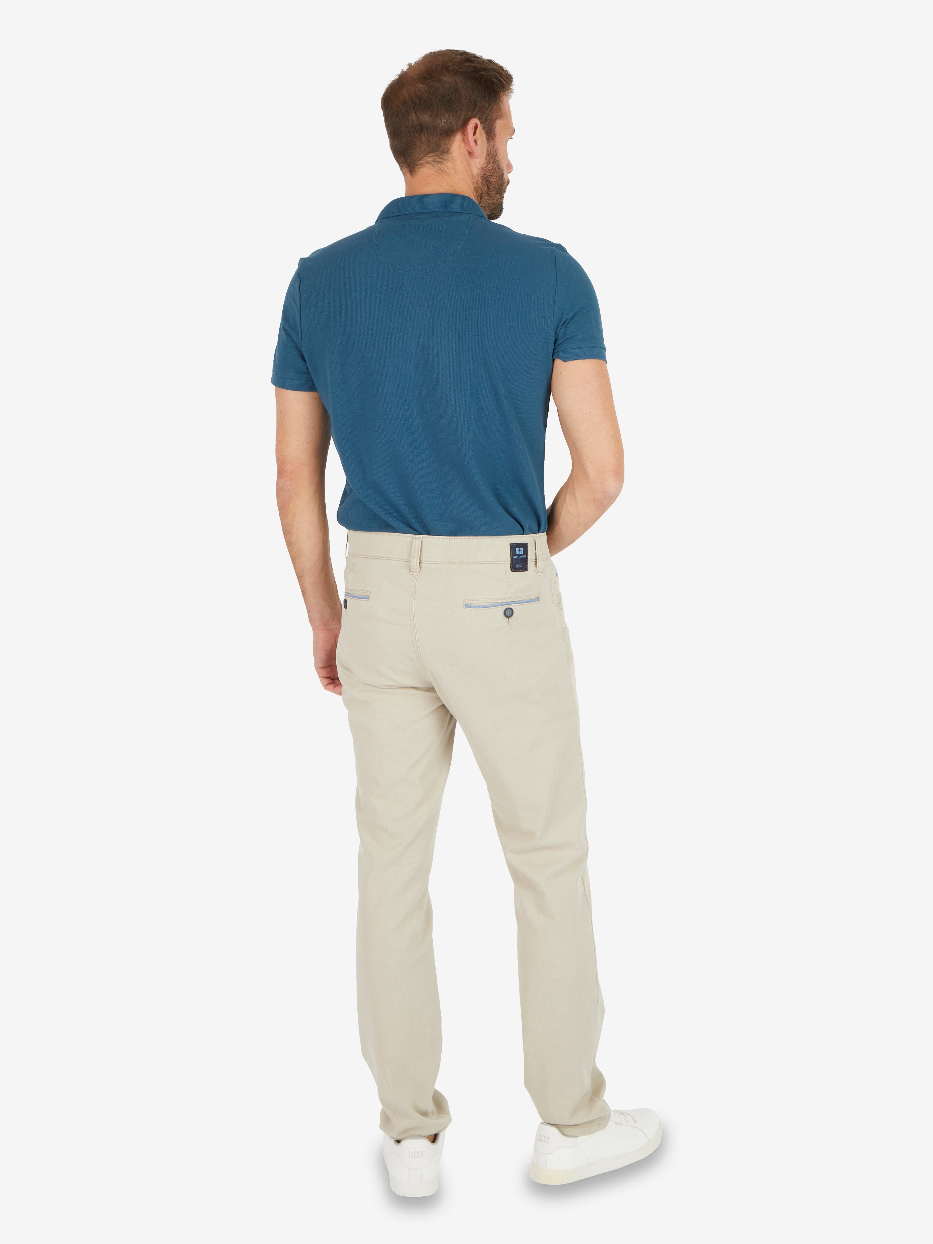 Frontansicht eines Mannes im blauen Polohemd und beigen Hosen, die MARVIN 7506 - beige aus hochwertiger Baumwolle mit elastischem Komfortbund, Hemdenstopper, Swing-Pocket, Kontrast-Patch, schlankem Bein, Regular Fit, Frühling/Sommer, nachhaltigem und komfortablem Design.