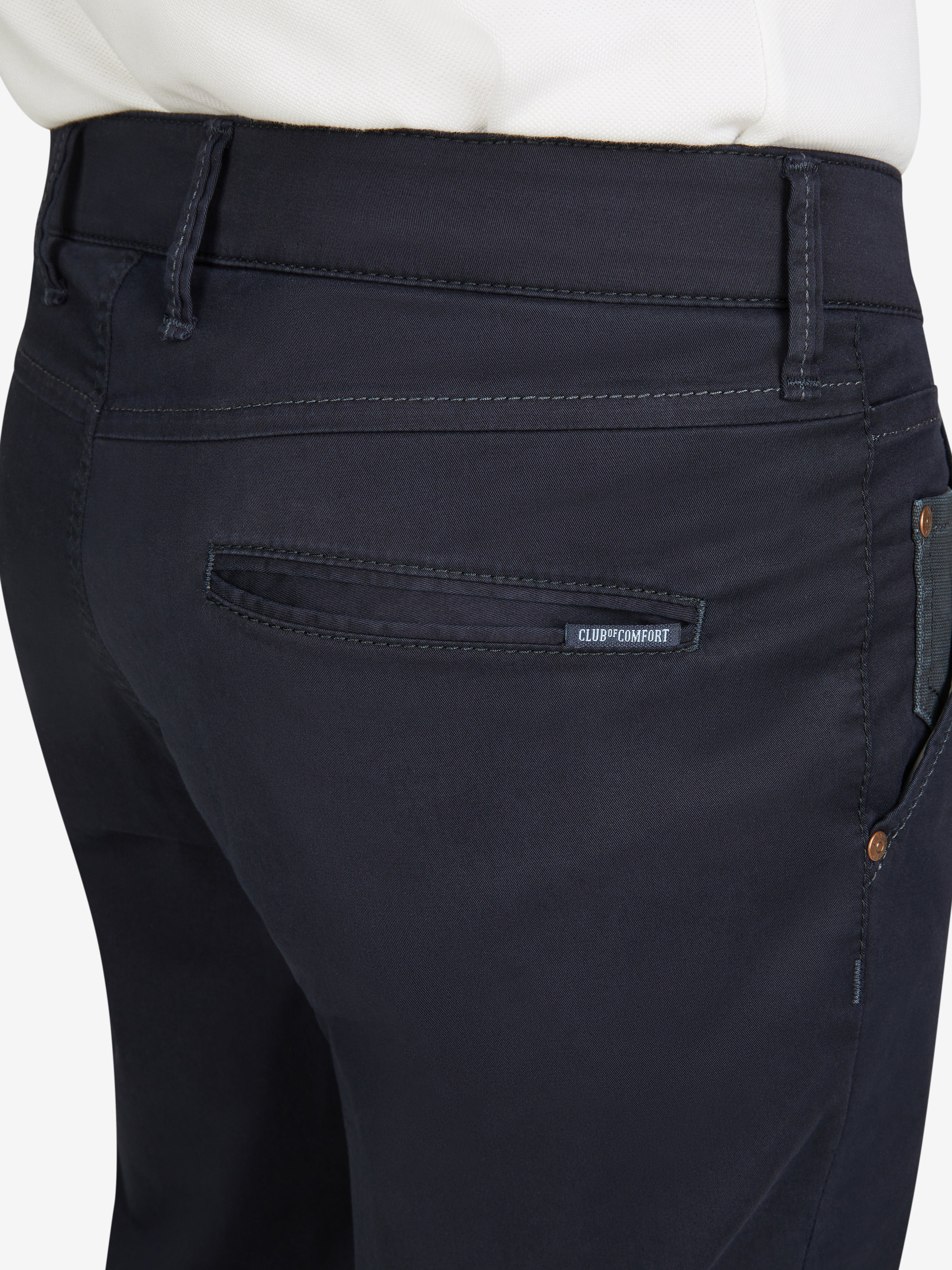 Nahaufnahme einer dunklen Chino-Hose in Slim Fit mit elastischem Comfortbund, Hemdenstopper und Münztasche, hergestellt von Club of Comfort, in Blau, aus leichtem Baumwoll-High-Stretch-Gewebe, mit schlankem Beinverlauf, visuell Details der Tasche und Passform.