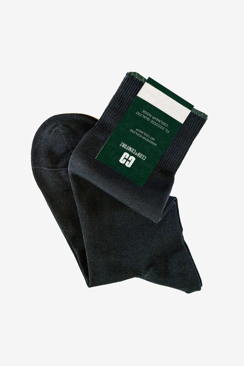 Schwarze Socken mit grüner Packungsrückseite, die einen Schläger- und Golf-Club-Entfernungsmesser bezeichnen, liegen übereinander.