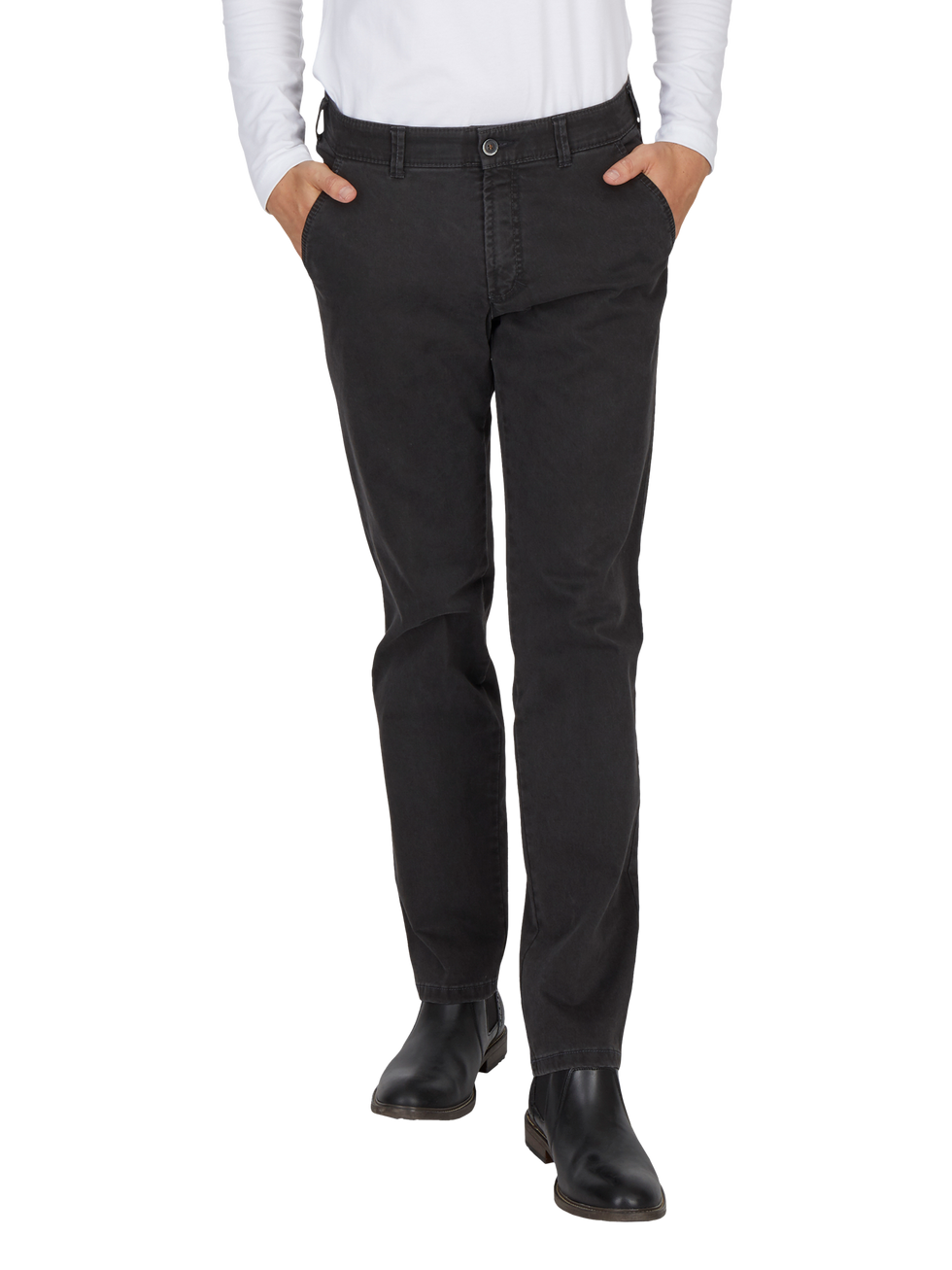 Ein Mensch trägt schwarze Jeans mit geradem Schnitt, ein weißes Hemd und schwarze Schuhe, die bis zu den Knöcheln reichen.