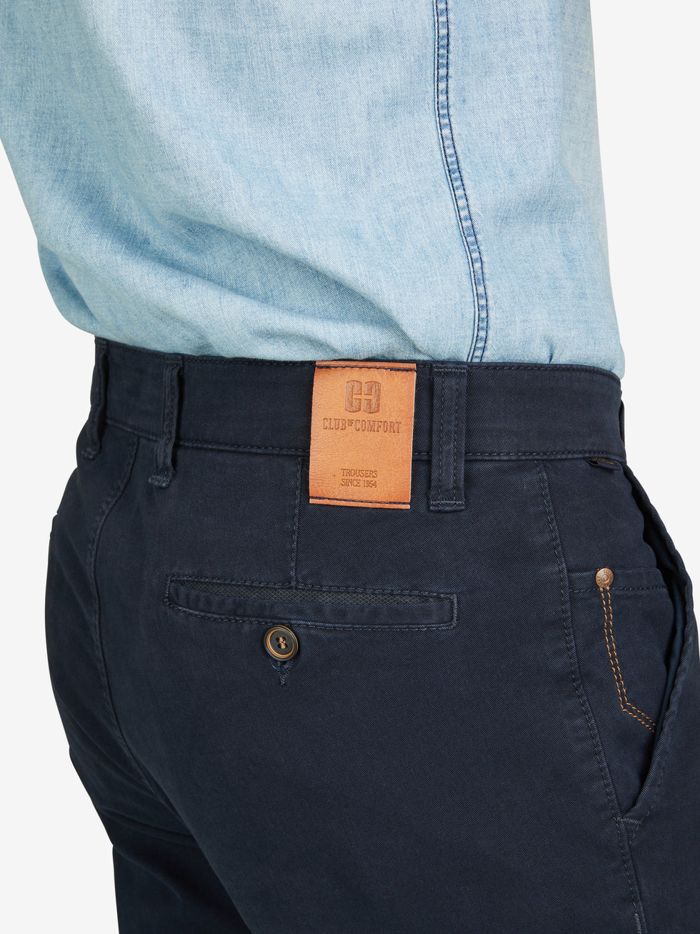 Nahaufnahme einer dunkelblauen Garvey 8070 Flat Front-Hose mit elastischem Komfortbund, Hemdstopper und Safety-Pocket, getragen von einem Model in hellblauem Hemd. Die Hose ist aus bi-elastischer Baumwolle gefertigt, hat eine normale Leibhöhe, schmalere Fußweite und ist für alle Jahreszeiten geeignet.