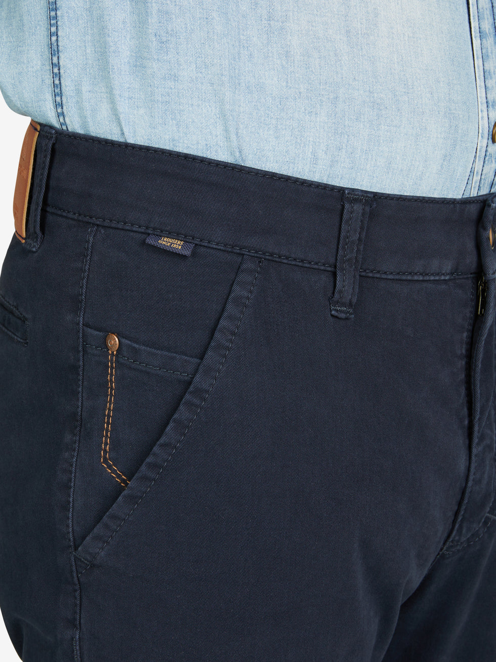 Nahaufnahme einer dunkelblauen GARVEY 8070 Flat Front-Hose mit elastischem Komfortbund, Hemdstopper und Münztasche, gefertigt aus bi-elastischer Baumwolle. Die Hose hat eine normale Leibhöhe, schmal zulaufenden Beinverlauf, und zeigt Details wie kontrastfarbene Steppnähte und Safety-Pocket.