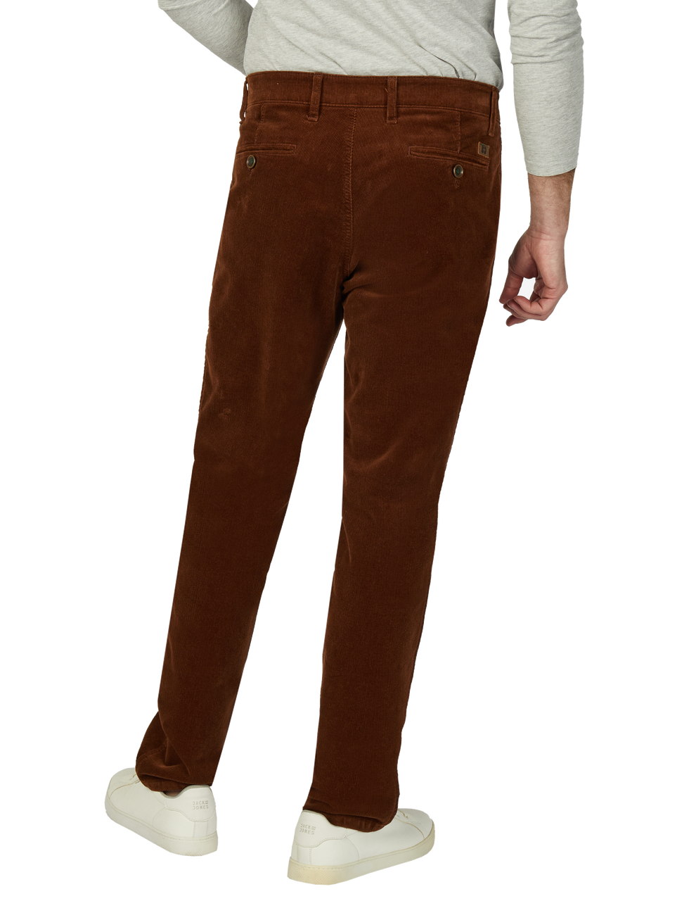 Blick auf eine Person, die braune Cordhosen trägt, sichtbar von hinten. Die Person trägt eine helle Graue Oberbekleidung und weiße Sneakers.