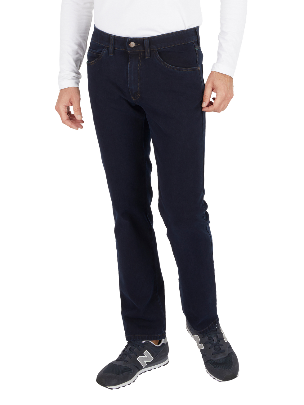 Ein Mann trägt dunkelblaue Jeans, ein weißes langärmliges Hemd und Sportschuhe von New Balance.