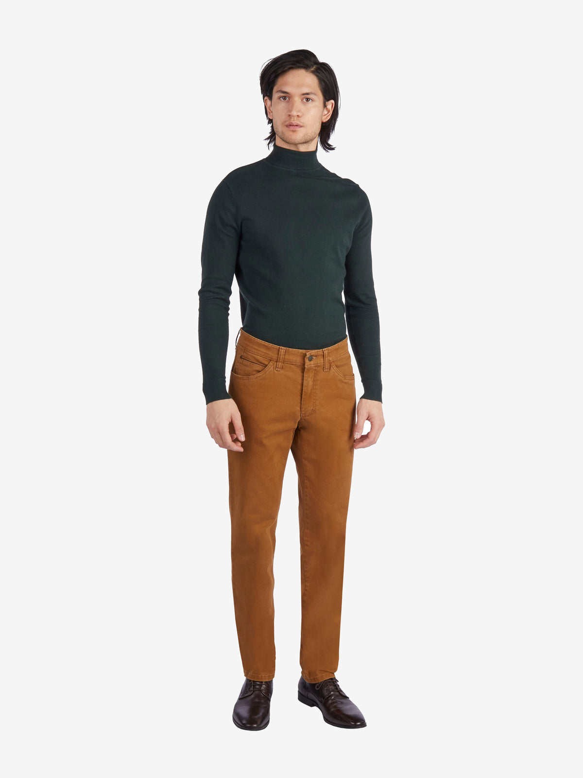 Mann in dunkelgrünem Rollkragenpullover und beiger HENRY 7612 - toffeebraune 5-Pocket-Hose aus elastischer Baumwolle, mit Mobile Pocket in der rechten Vordertasche, normaler Leibhöhe, schlankem Bein, auf weißem Hintergrund.