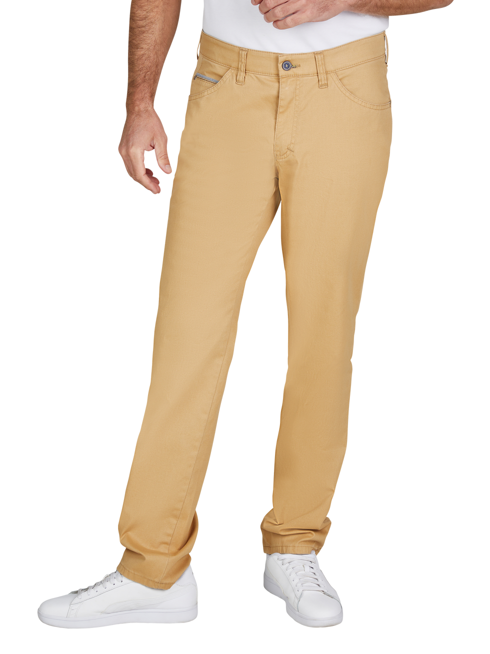 Hosenbild: Ein Mann trägt beige Chino-Hosen, die gerade sitzen und eine klassische Passform haben. Die Hosen haben einen Knopf und einen Reißverschluss, drei Eingrifftaschen vorne und zwei Gesäßtaschen. Der Mann trägt weiße Sneakers und ein weißes T-Shirt.