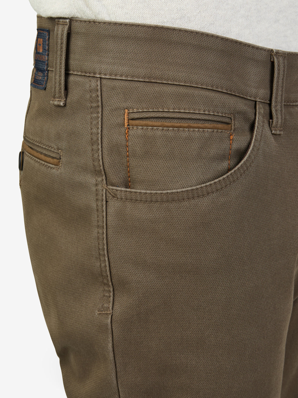 Nahaufnahme einer beigen MARVIN 8025 Hose von Club of Comfort mit elastischem Comfortbund, Hemdstopper, doppelt paspelierte Münztasche, aus High Stretch Baumwoll-Struktur mit Thermolite-Wärmeisolierung, modifizierte 5 Pocket, normaler Leibhöhe, schlankes Bein, im Herbst/Winter.