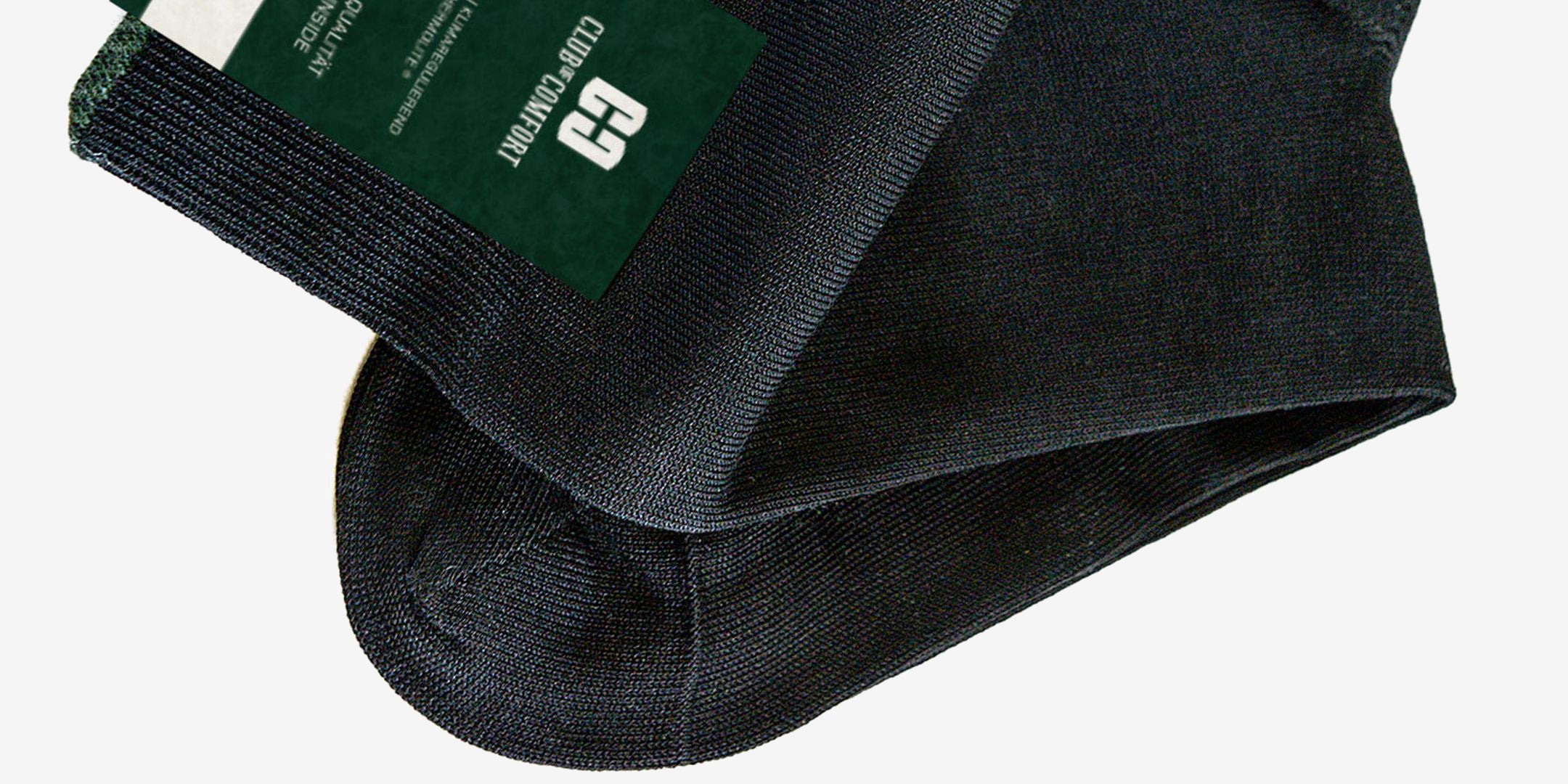 Ein schwarzer Gegenstand aus Stoff, vermutlich eine Tasche oder Hülle, mit einem grünen und weißen Etikett, auf dem Text sowie Zahlen stehen.