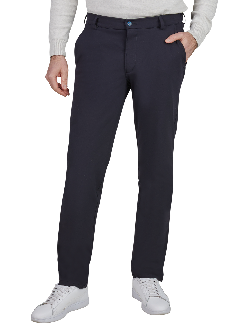 Hosen eines Mannes, der eine graue Langarm-Top trägt, mit einer Hand in der Tasche. Die Hose ist dunkelblau, hat eine Gürtelschlaufe, Reißverschluss und Knopf, sowie seitliche Eingrifftaschen. Er trägt weiße Turnschuhe.